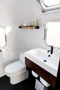 La salle de bains blanche est pourvue de toilettes et d'un lavabo. dans l'établissement AutoCamp Yosemite, à Midpines