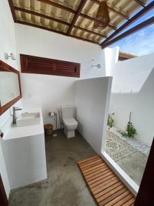 a white bathroom with a toilet and a sink at Os Navegantes -Casa Vento in Icaraí