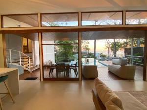 a living room with glass doors and a dining room at Villa Laia - Santa Teresa in Santa Teresa Beach