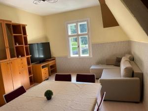 a living room with a couch and a tv at Haus Rheinberg Gästehaus in Lorch am Rhein