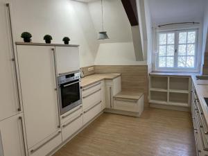 a large kitchen with white cabinets and a window at Haus Rheinberg Gästehaus in Lorch am Rhein