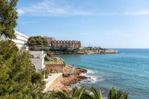 a view of the ocean with buildings on the shore at Playa-Piscina-Port Aventura4 in Salou