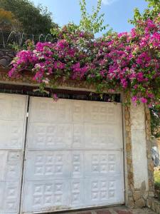 a garage door with pink flowers on top of it at La Casa de Luna in Carmen de Apicalá