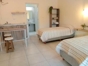 a room with two beds and a kitchen with a sink at Casa Tierra Verde Oliva in Ciudad Lujan de Cuyo +39 photos
