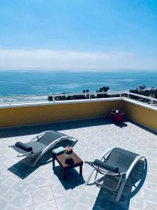 2 stoelen en een tafel op een balkon met uitzicht op de oceaan bij Ático frontal con vistas al mar - 1ª línea Acapulco I in Oropesa del Mar