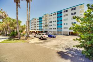 um parque de estacionamento em frente a um edifício com palmeiras em Oceanview Condo on Satellite Beach! em Satellite Beach