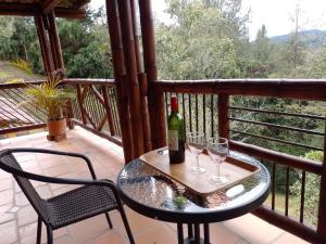 uma mesa com 2 copos e uma garrafa de vinho na varanda em La Casona Del Retiro em Medellín