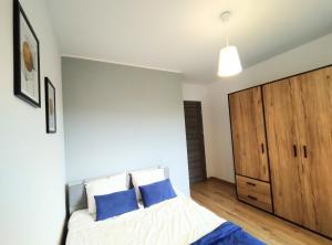 - une chambre avec un lit et une armoire en bois dans l'établissement Garden Apartment, à Wieliczka