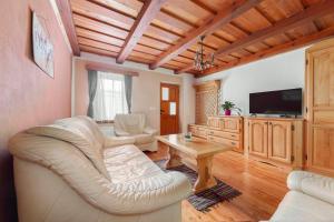 ein Wohnzimmer mit einem weißen Sofa und einem Tisch in der Unterkunft Goričko Relax House in Kuzma