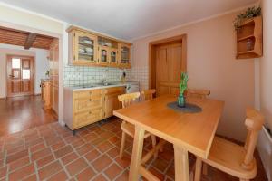 eine Küche mit einem Holztisch und einem Esszimmer in der Unterkunft Goričko Relax House in Kuzma