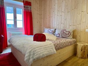 een slaapkamer met een bed met een rode rugzak erop bij Chalet Ame in Bormio