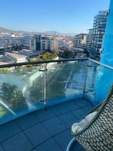 a balcony with a chair and a view of a city at Ocean Village Lovely 2 bedroom apartment in Gibraltar
