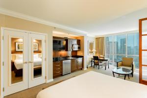 a hotel room with a king sized bed and a living room at MGM Signature, Centrally Located, Strip Views NO RESORT FEE in Las Vegas
