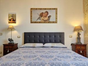 a bedroom with a large bed with a blue bedspread at “Attico Garibaldi” nel cuore della Toscana in Sinalunga