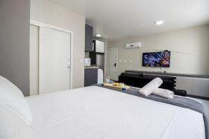 a large white bed in a room with a tv at POS25B - Climatizado, TV Smart, Garagem, Wi-Fi in Balneário Camboriú