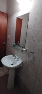 a bathroom with a white sink and a mirror at Agus-Marti in Nueve de Julio