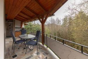 eine Terrasse mit einem Tisch und Stühlen auf dem Balkon in der Unterkunft Goričko Relax House in Kuzma