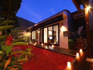 a house with lights in the yard at night at Grania Bali Villas in Seminyak