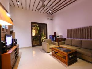 sala de estar con sofá y TV en Grania Bali Villas, en Seminyak