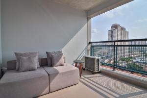 uma sala de estar com um sofá e uma varanda em 360 Vita Bom Retiro em São Paulo