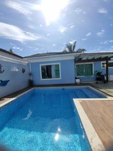 - une piscine en face d'une maison dans l'établissement Casa Azul - Linda casa Familiar com Piscina no Peró em Cabo Frio, à Cabo Frio
