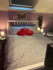 dois corações sentados em cima de uma cama em Tuebrook Towers em Liverpool