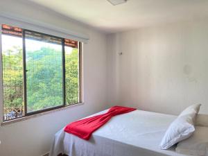 een slaapkamer met een bed met een rode deken erop bij Chalé Novo - 4 quartos - 12 camas - Hidromassagem e Ar condicionado nos quartos - Cond Montserrat in Guaramiranga