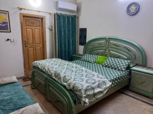 a bedroom with a green bed in a room at 3 Bedroom House right In-between Twin Cities in Rawalpindi