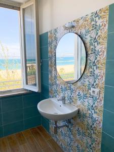 uma casa de banho com um lavatório e um espelho em Conero-30 mt dal Mare, Balcone V i s t a Mare e Spiaggia di sabbia em Porto Potenza Picena