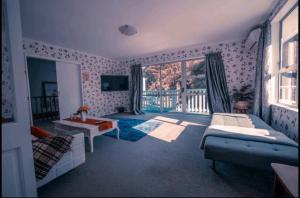 a living room with a couch and a table at Warm, tidy , quiet vacation home in Wellington