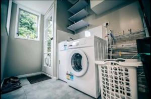 a washing machine in a laundry room with a window at Warm, tidy , quiet vacation home in Wellington