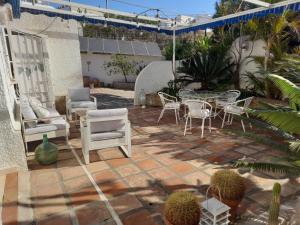 a patio with a table and chairs and plants at HABITACION EN CASA MIGUEL in Caleta De Velez