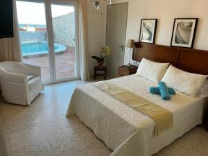 a bedroom with a bed and a chair and a pool at HABITACION EN CASA MIGUEL in Caleta De Velez