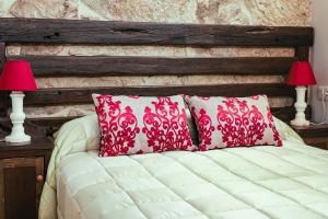 a bed with two red and white pillows and two lamps at Pepita Carnera in Marín