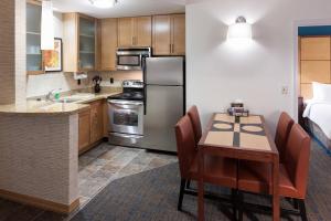 a kitchen with a table and a room with a bed at Residence Inn Phoenix North Happy Valley in Phoenix