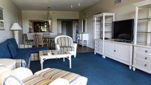 a living room with a couch and a tv at Longboat Bay Club in Longboat Key