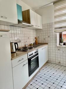 een keuken met witte kasten en een oven bij Ferienwohnung in der schönen Rhön in Stadtlengsfeld