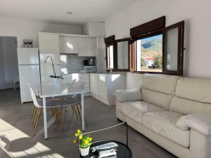 a living room with a couch and a table and a kitchen at Apartamentos Torreón de Manuela in La Calahorra