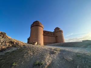 a castle on a hill with a blue sky at Apartamentos Torreón de Manuela in La Calahorra