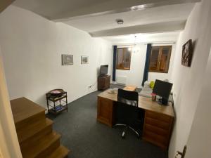 una oficina con escritorio y sillas y una escalera en Maison 2 minute de la place de la republique, en Limoux