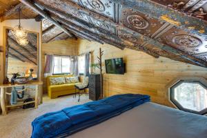 una camera con un letto in una stanza con pareti in legno di Idaho Springs Cabin with Hot Tub on Half Acre! a Idaho Springs