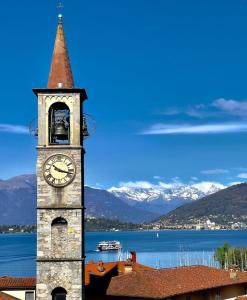 una torre con un reloj en la parte superior de un edificio en La finestra sul lago, appartamento in pieno centro en Laveno