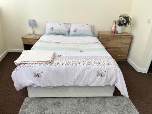 a bedroom with a bed with a white comforter at Two Bed Town Apartment in Rotherham