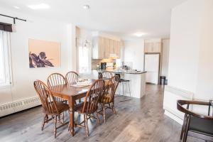 a kitchen and dining room with a wooden table and chairs at Le Downtown Tremblant • Logement in Mont-Tremblant