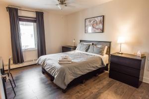 a bedroom with a bed with two towels on it at Le Downtown Tremblant • Logement in Mont-Tremblant
