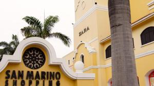 a yellow building with a palm tree in front of it at Junior Suite a few minutes from shopping centers and airport in Guayaquil