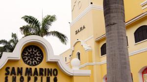 un edificio amarillo con una palmera delante en Junior Suite a few minutes from shopping centers and airport, en Guayaquil