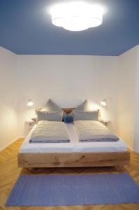 Das Altschwabing - Munich Boutique Hotel في ميونخ: غرفة نوم مع سرير كبير مع ضوء على السقف
