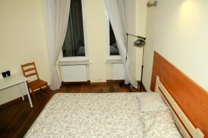 1 dormitorio con 1 cama, 1 mesa y 2 ventanas en Economic Mandala Apartment en Poznan