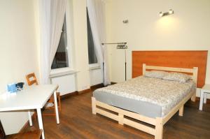 1 dormitorio con cama, mesa y ventanas en Economic Mandala Apartment en Poznan